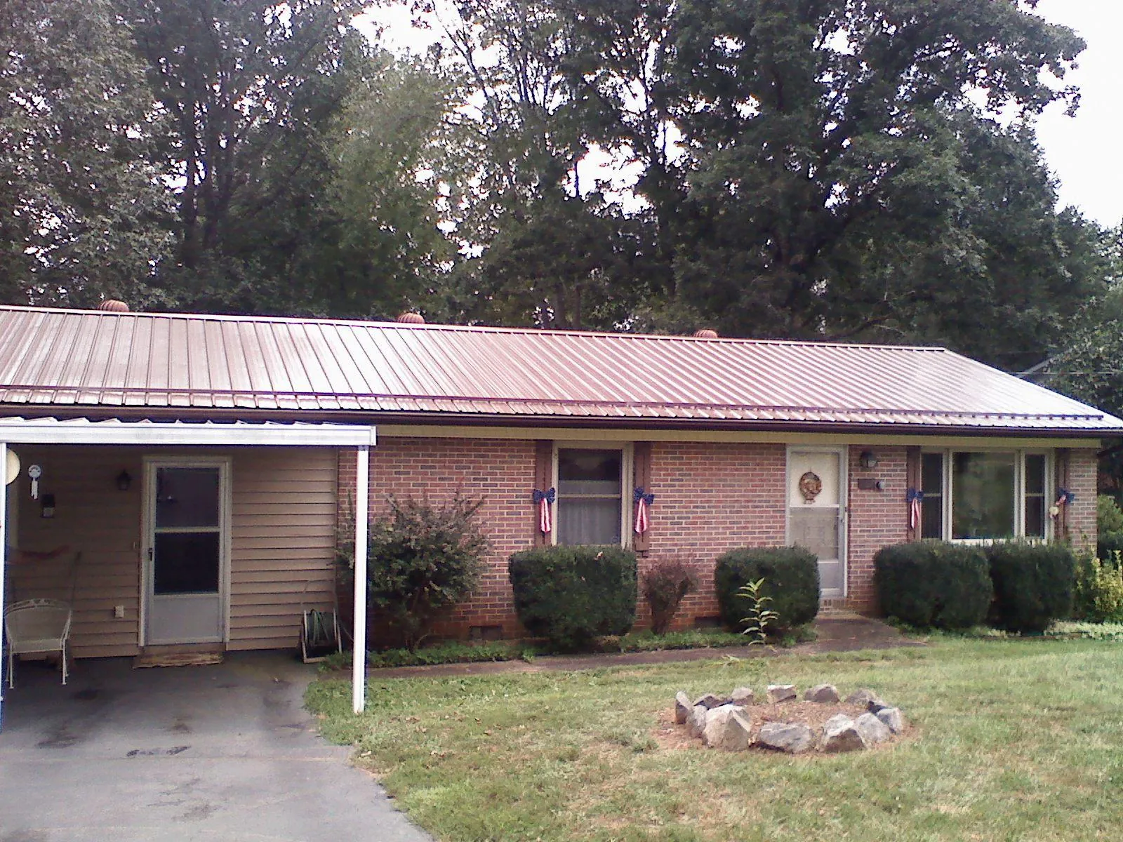 Bronze metal roof and carport on a brick ranch home — Roof Repair work by our crew in Belle Chasse