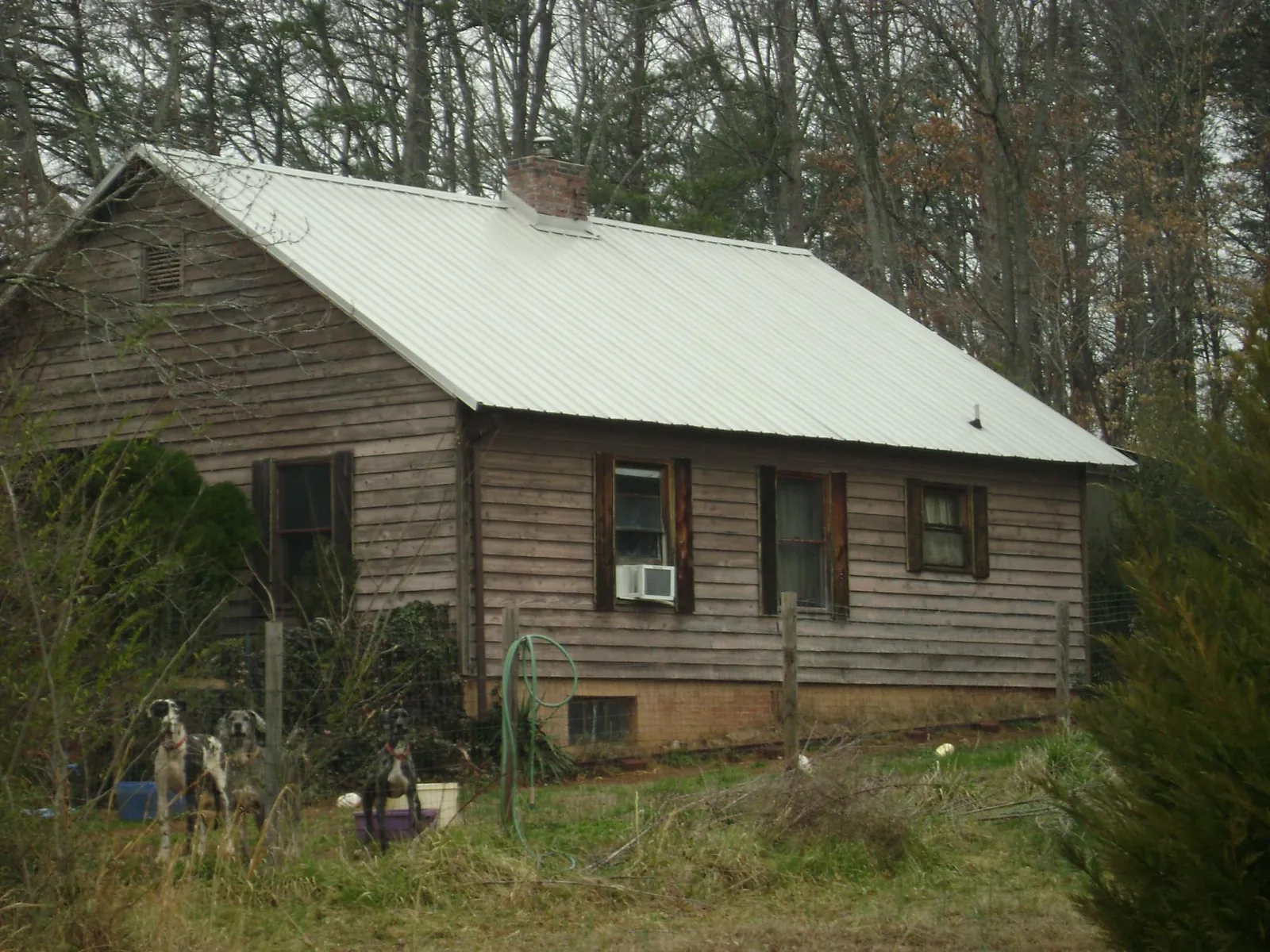 White metal roof on an old wood sided farmhouse, from a Metal Roof Installation job in Belle Chasse